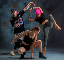 Image showing The two young girsl and boy dancing hip hop in the studio