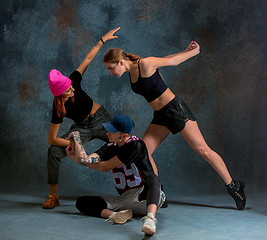 Image showing The two young girsl and boy dancing hip hop in the studio