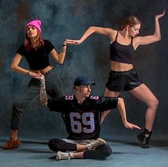 Image showing The two young girsl and boy dancing hip hop in the studio