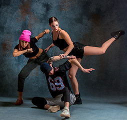 Image showing The two young girsl and boy dancing hip hop in the studio