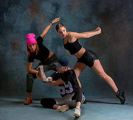 Image showing The two young girsl and boy dancing hip hop in the studio