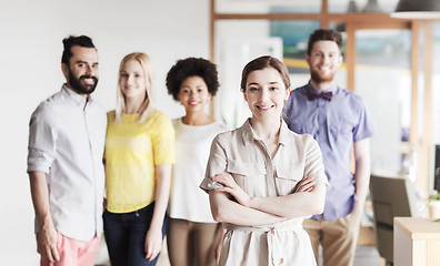 Image showing happy young woman over creative team in office