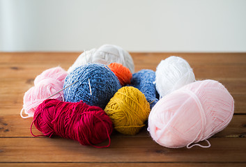 Image showing knitting needles and balls of yarn on wood