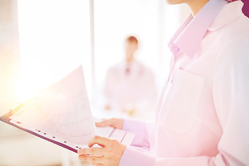 Image showing female holding clipboard with cardiogram