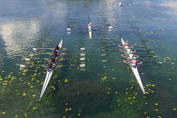 Image showing Young athletes rowing on the tranquil lake