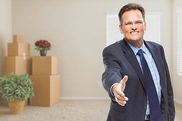 Image showing Businessman Reaching for Hand Shake in Room with Packed Boxes