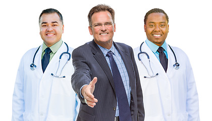 Image showing Mixed Race Doctors Behind Businessman Reaching for Hand Shake on