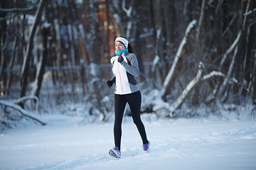 Image showing Young brunette running among trees