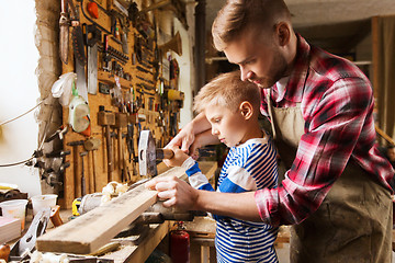 Image showing father and son with hammer working at workshop