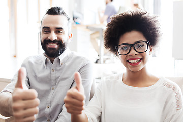 Image showing happy creative team in office showing thumbs up