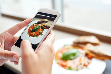 Image showing hands with gazpacho soup photo on smartphone