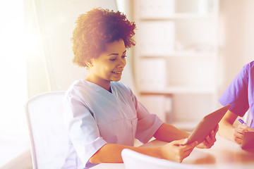 Image showing happy female doctor or nurse with tablet pc