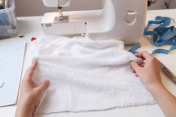 Image showing Woman prepares fabric for sewing