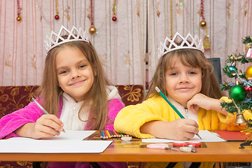 Image showing Two girls write wishes for the new year