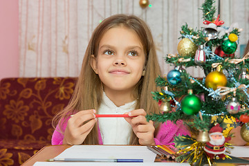 Image showing Happy little girl thinking of a gift for the new year