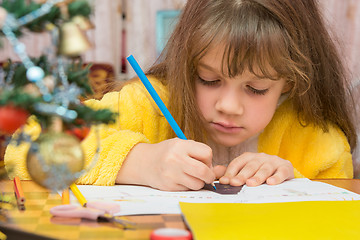 Image showing Carried away by a girl making Christmas crafts