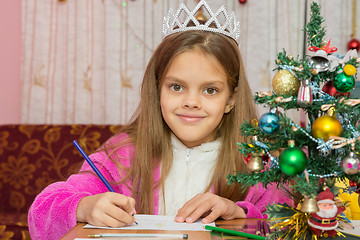 Image showing A girl waiting for a new year, writes a letter to the desires and looked into the frame