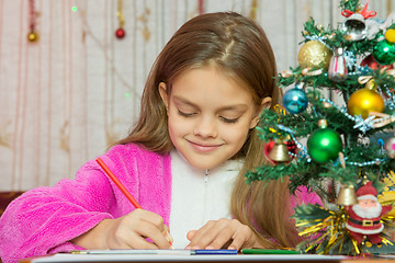 Image showing Girl writes New Year greetings
