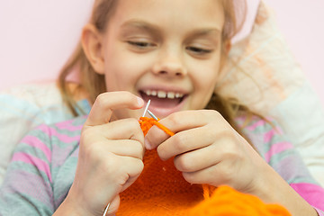 Image showing Happy girl knits on the needles, close-up, focus on the spokes