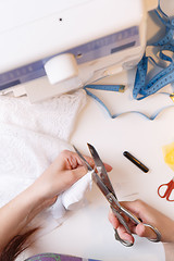 Image showing Woman cuts thread in fabric