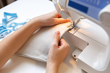 Image showing Woman sews fabric on machine