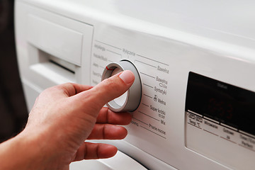 Image showing man's hand adjusting washing machine