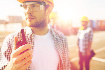 Image showing close up of builder in hardhat with walkie talkie