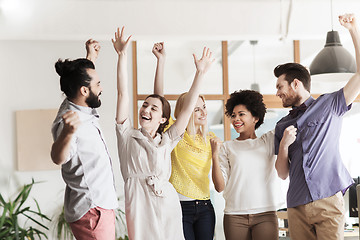 Image showing happy creative team celebrating victory in office