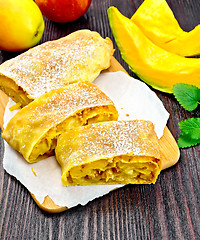 Image showing Strudel pumpkin and apple with raisins on dark board