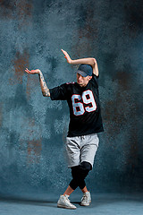 Image showing Young man break dancing on wall background.