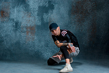 Image showing Young man break dancing on wall background.