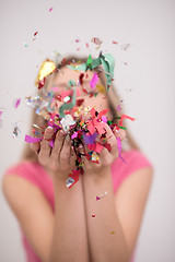 Image showing woman blowing confetti in the air