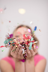 Image showing woman blowing confetti in the air