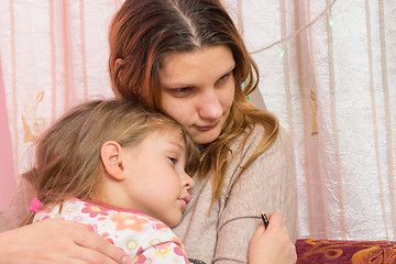 Image showing Sad five year old girl hugging her mother