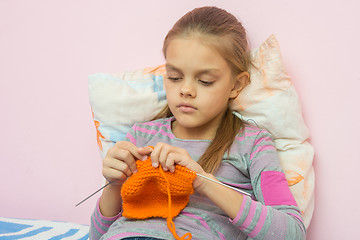 Image showing The girl knits on spokes sitting on the bed