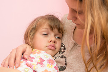 Image showing Sad five year old girl clung to her mother