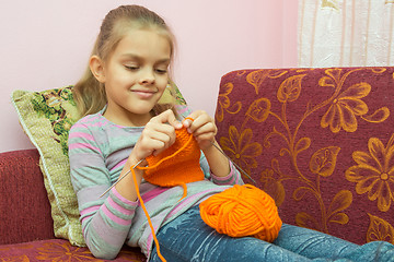 Image showing Girl lying on the couch and knits on spokes