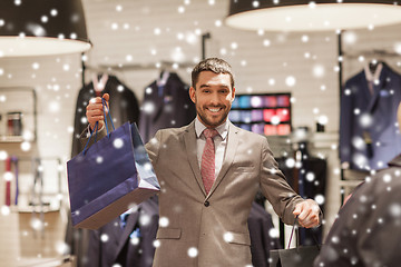 Image showing happy man with shopping bags at clothing store