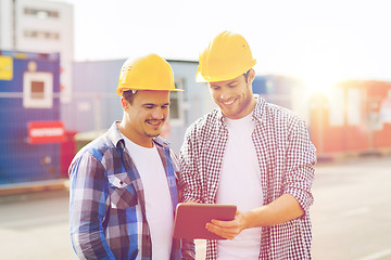 Image showing smiling builders in hardhats with tablet pc