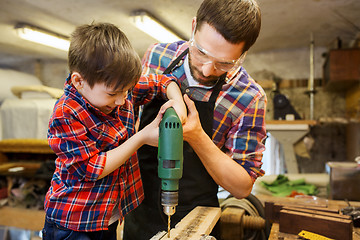 Image showing father and son with drill working at workshop