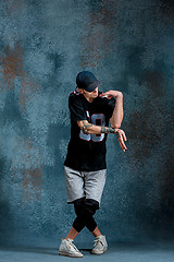 Image showing Young man break dancing on wall background.