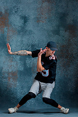 Image showing Young man break dancing on wall background.