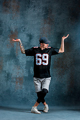 Image showing Young man break dancing on wall background.