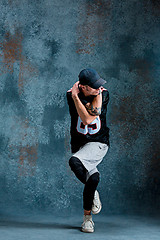 Image showing Young man break dancing on wall background.