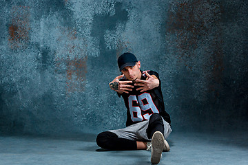 Image showing Young man break dancing on wall background.