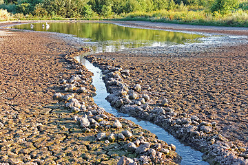 Image showing Water stream flows into the pond shrinking