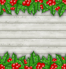 Image showing Christmas decoration holly berry branches on wooden background 