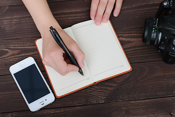 Image showing Top view of a hands with pen and notepad