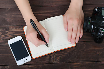 Image showing Top view of a hands with pen and notepad