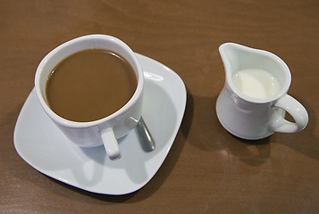 Image showing Cup of coffee and milk jar